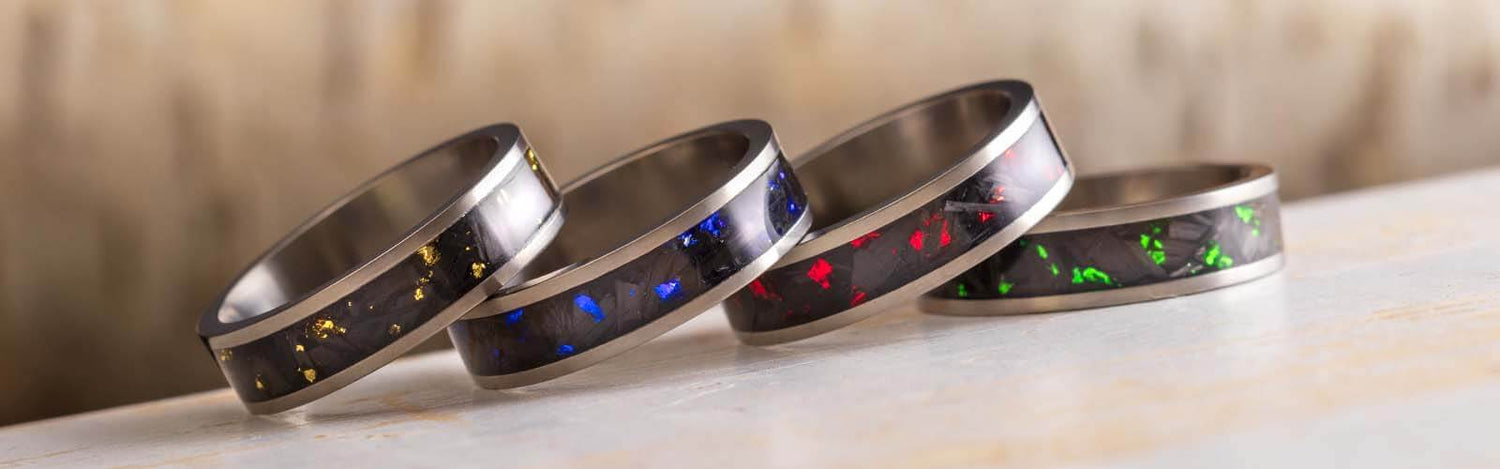 Carbon Fiber Wedding Bands stacked on a flat surface | Jewelry by Johan