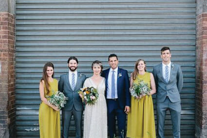 A joyful wedding party gathered in celebration, with the bride and groom at the center surrounded by friends and family, all dressed in elegant attire, capturing a moment of love and unity.