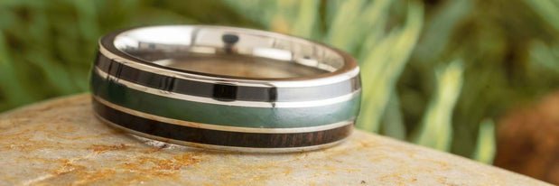 A close-up of a decorative ring resting on a stone surface.