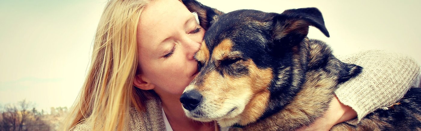 Lady kissing senior dog