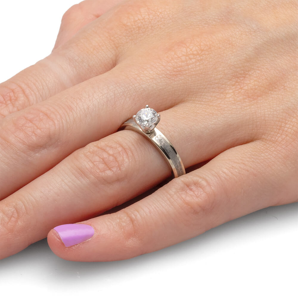 Close-up of a 0.75-carat diamond ring on a hand, showing the round diamond in a prong setting.