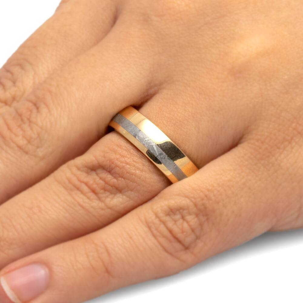 Meteorite gold ring with oak inlay on finger