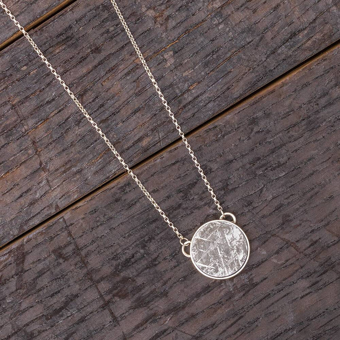 Meteorite necklace on wooden background