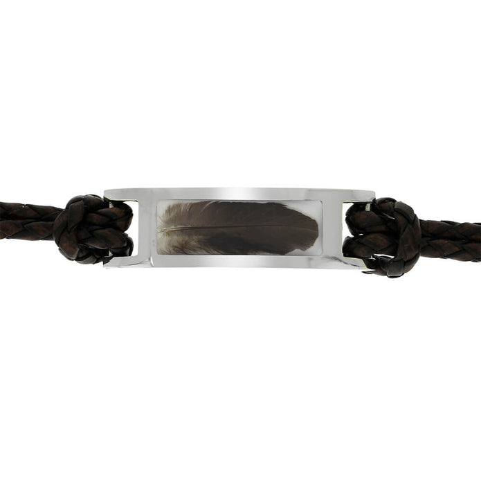 Bracelet with a silver tag featuring a feather, wrapped in brown leather cord on a white background.