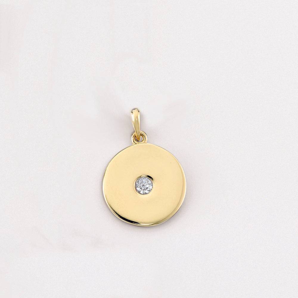 Close-up of diamond disc pendant in yellow gold