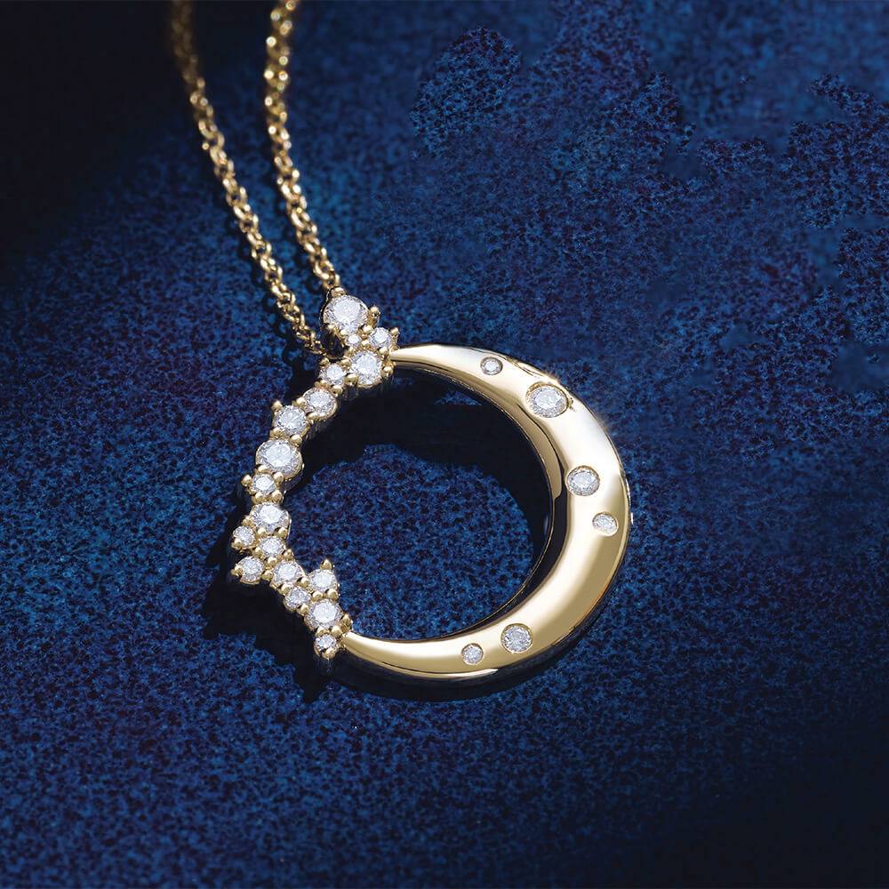 Diamond crescent moon necklace on blue background
