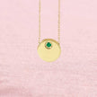 Emerald circle slide necklace on pink background