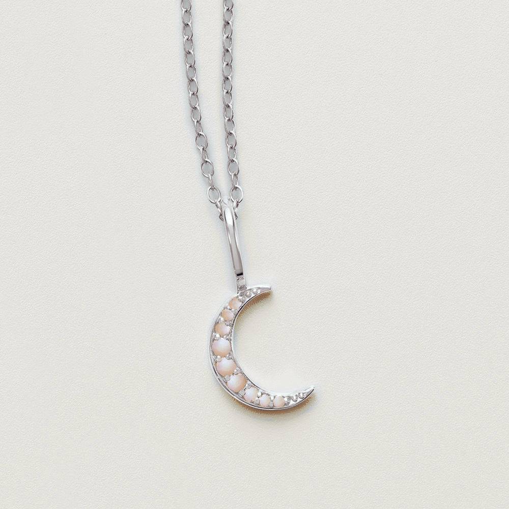 White opal crescent moon necklace on display