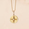 Gold compass necklace with natural diamonds on display