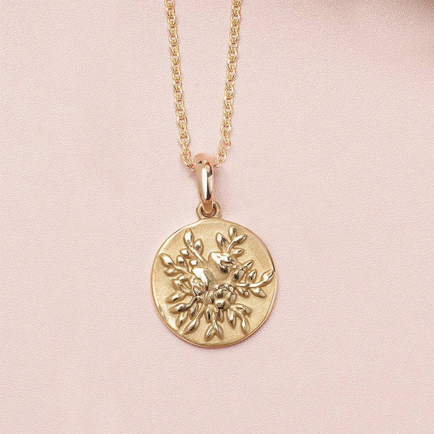 Yellow gold circle necklace with floral design on chain