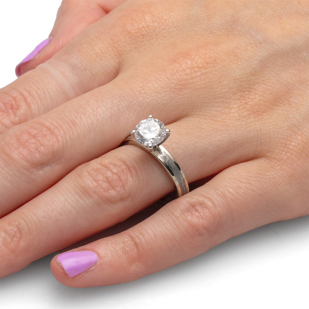 Detailed view of a 2.0-carat diamond ring on a hand, featuring a classic silver band.