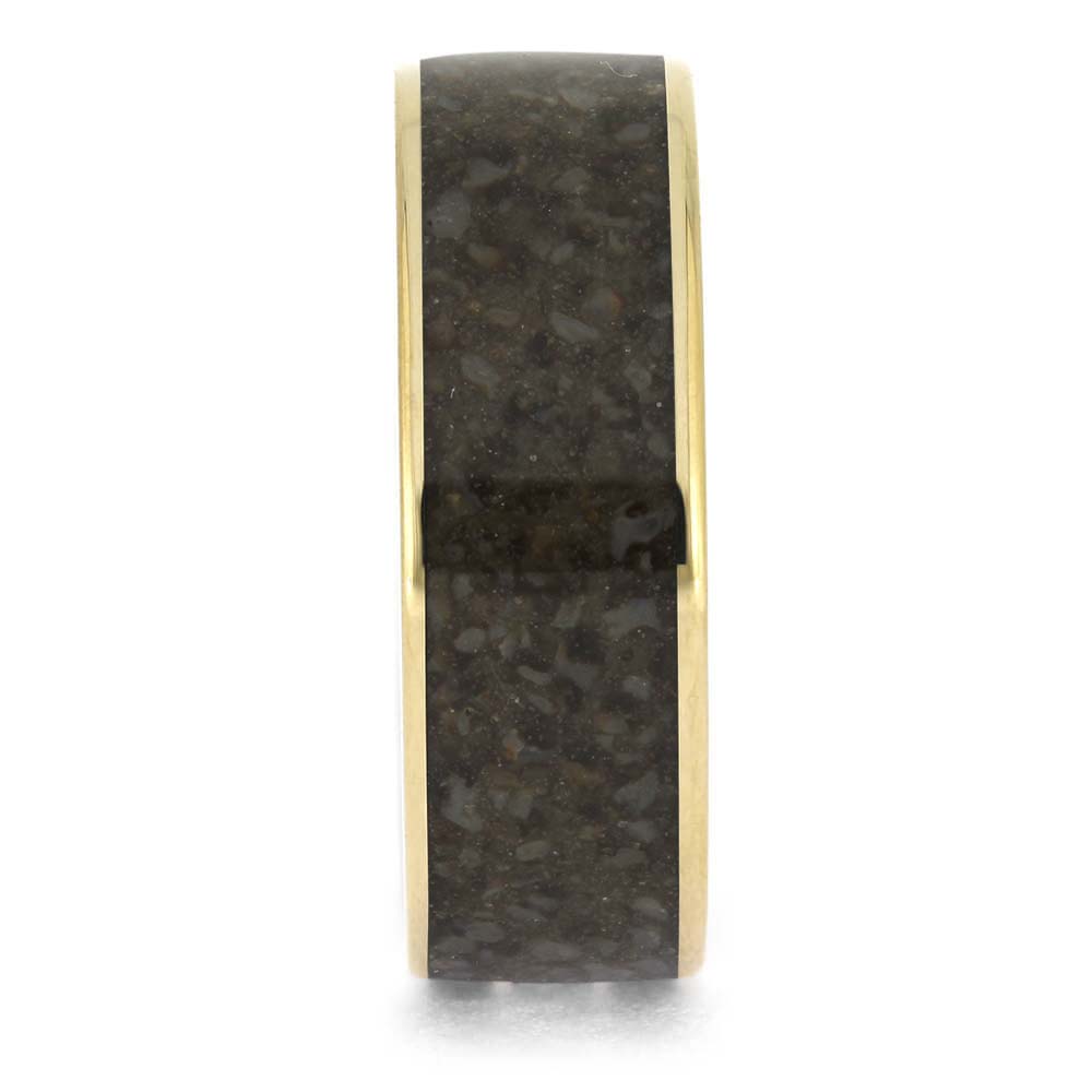 Gold ring with a black stone inlay on a white background