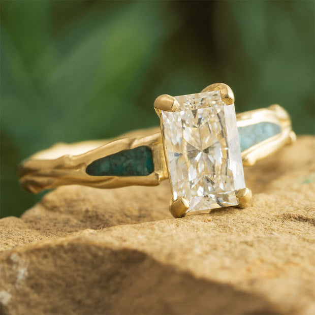 Gold ring with a large diamond on a textured surface