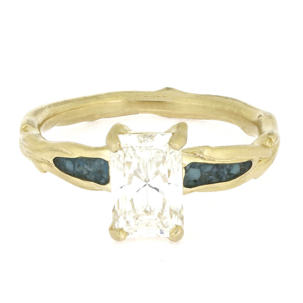 Gold ring with a central diamond and blue gemstones on a white background