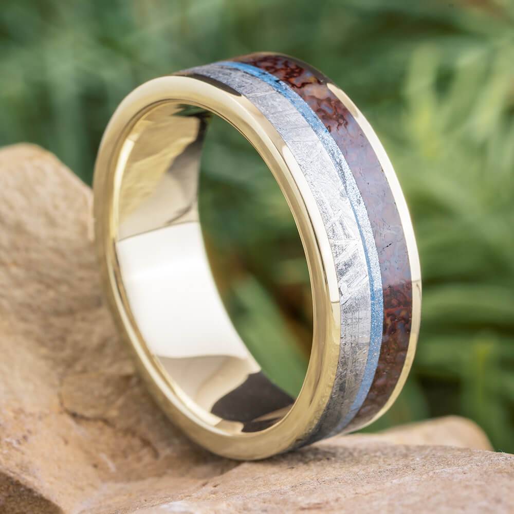 White gold ring with meteorite and dino bone inlays on rock