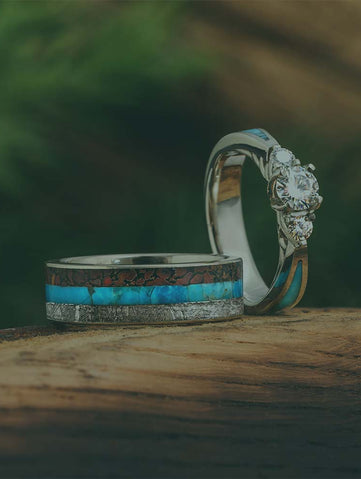 Two rings with turquoise inlay on a wooden surface