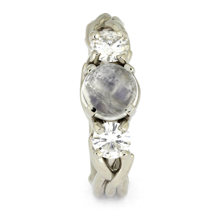 Silver ring with three gemstones on a white background