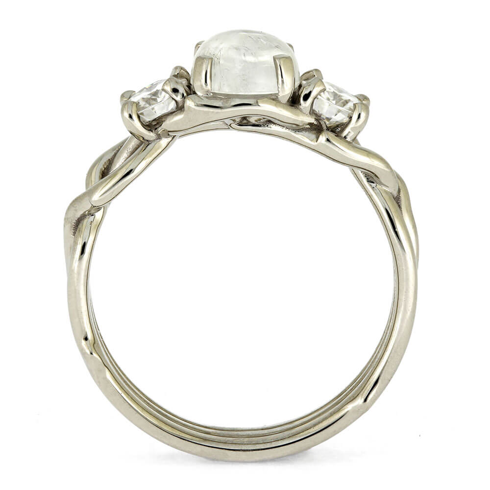 Silver ring with a central gemstone and two smaller stones on a white background