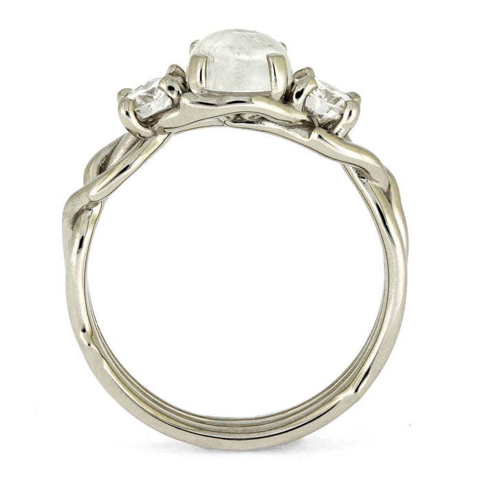 Silver ring with a central gemstone and two smaller stones on a white background