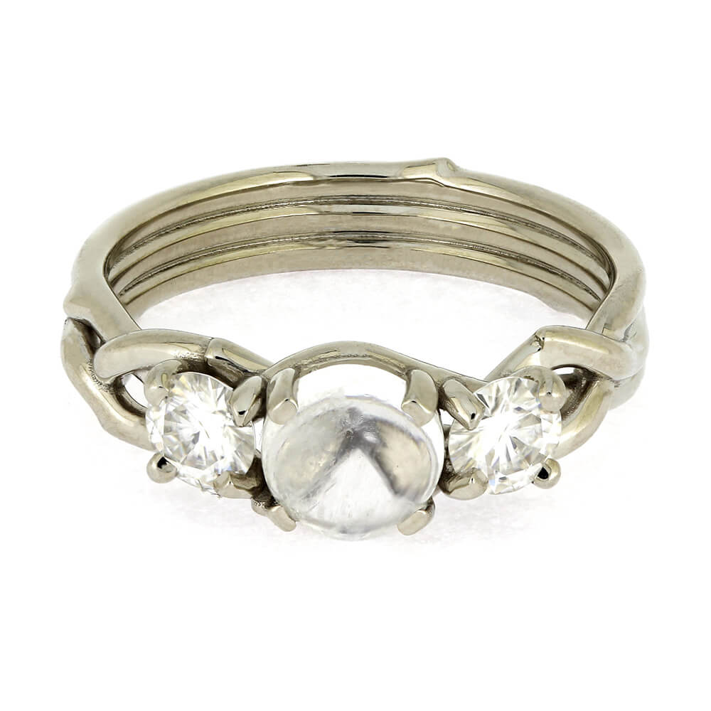 Silver ring with a central pearl flanked by two diamonds on a white background