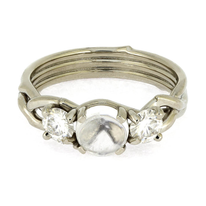 Silver ring with a central pearl flanked by two diamonds on a white background