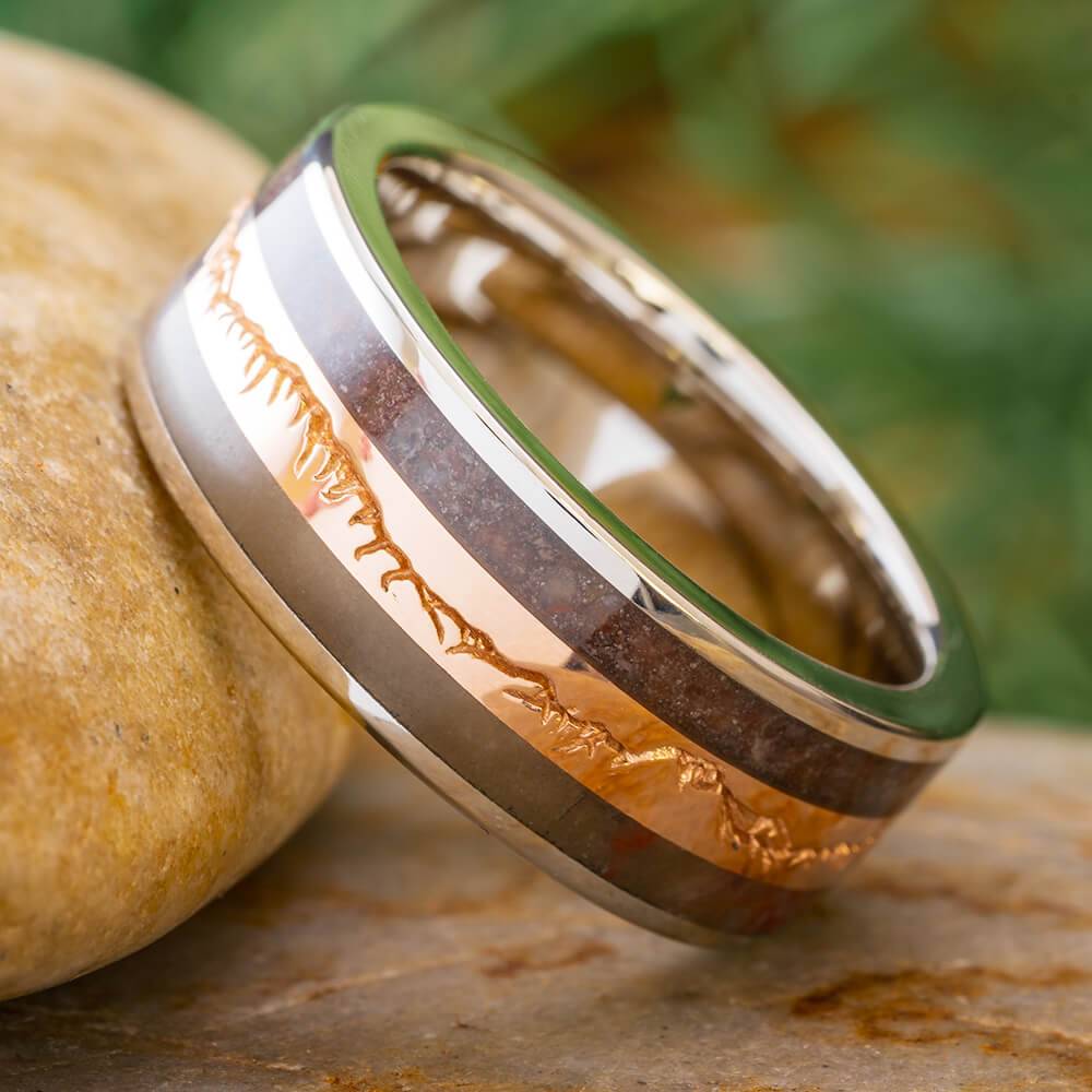 Fossilized wood wedding band with gold mountain design on stone