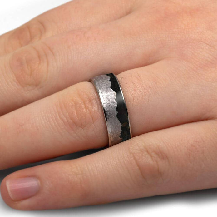Meteorite mountain ring with dinosaur bone on finger