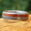 Cremation ring with wood and ashes inlays on wood surface.
