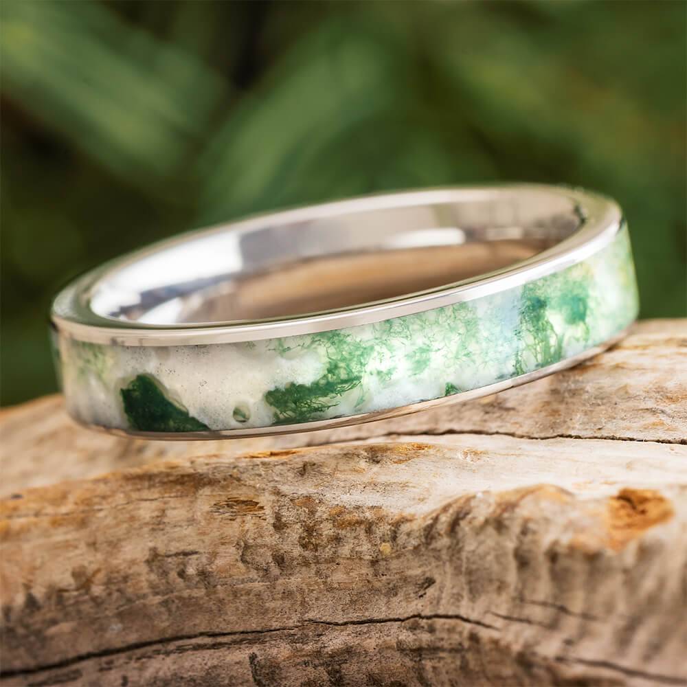 Moss agate wedding band in titanium on wood