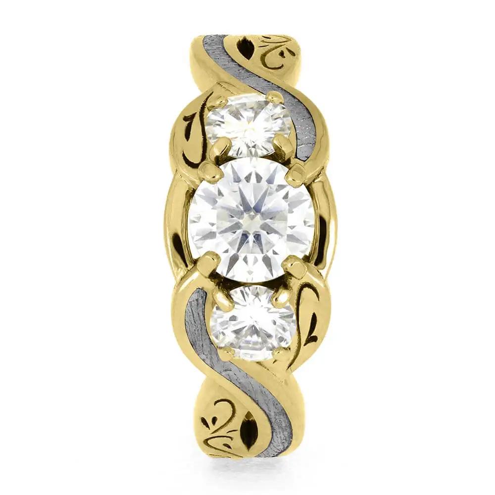 Front view of three stone yellow gold ring with meteorite accents