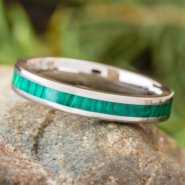 Narrow green malachite wedding band on rock