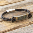 Bracelet with braided brown leather strap on a wooden surface