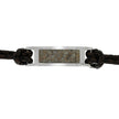 Bracelet with leather strap and metallic tag on a white background