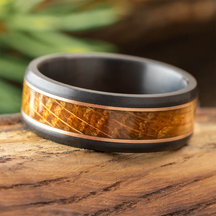 Men's Black Zirconium Ring with Whiskey Barrel wood inlay and dual Rose Gold pinstripes, 8mm beveled profile, matte finish.