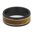 Flat-lay of Whiskey Barrel Wedding Band highlighting the rich brown oak wood inlay and contrasting white gold trim in a matte black zirconium band.
