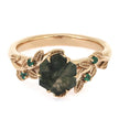 Gold ring with a green gemstone on a white background