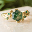 Gold ring with a green gemstone on a light surface