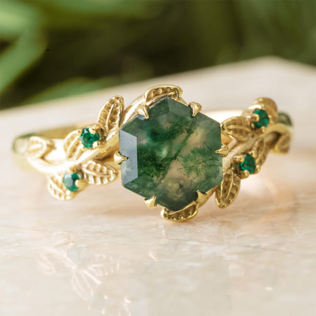 Gold ring with a green gemstone on a light surface