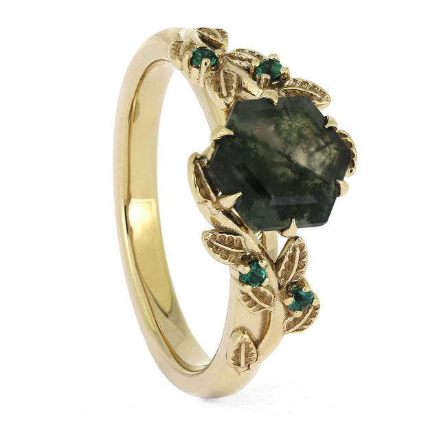 Gold ring with green gemstones on a white background