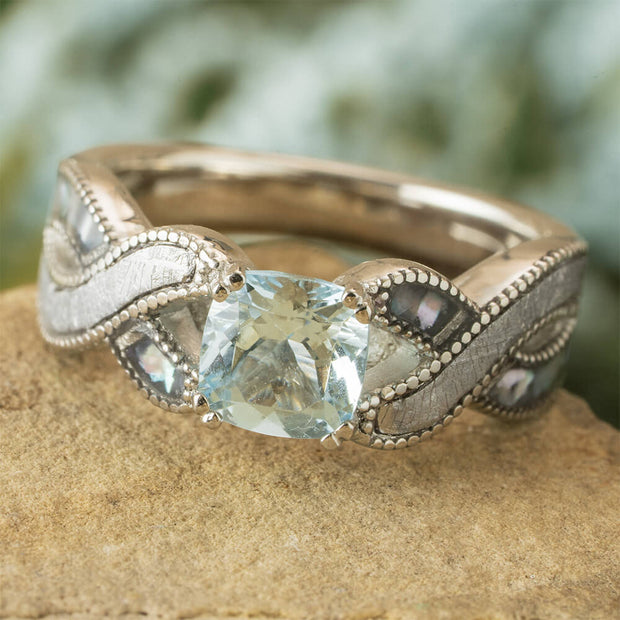 Silver ring with a large blue gemstone on a stone surface