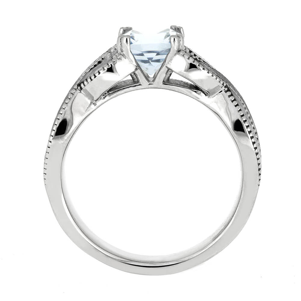 Silver ring with a central gemstone on a white background