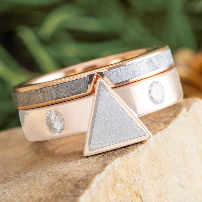 Two gold rings with geometric designs on a natural background