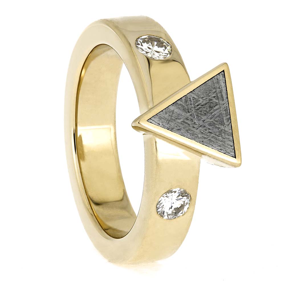 Gold ring with triangular design and embedded crystals on a white background