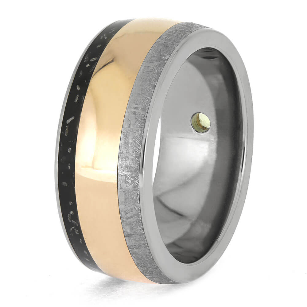 Titanium men's ring with rose gold band, black meteorite inlay, and green peridot gem. Unique cosmic design with polished finish.