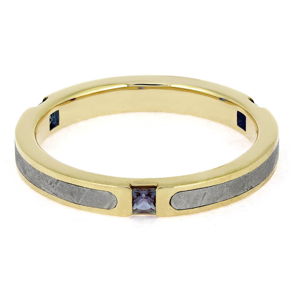 Gold ring with embedded gemstones on a white background