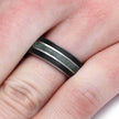 Ring with black and silver band on a finger