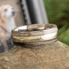 Two-tone ring on a stone surface with a blurred background