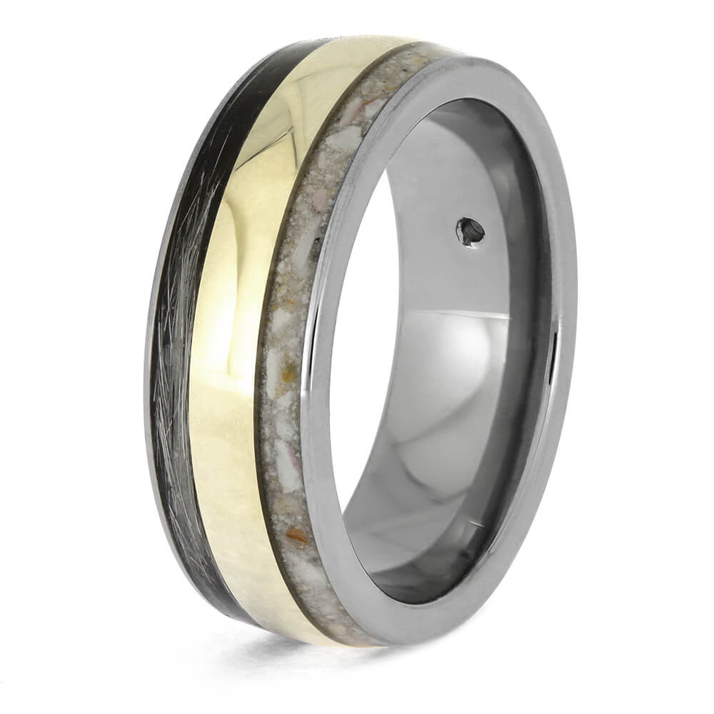 Multicolored ring with gold, silver, and black elements on a white background