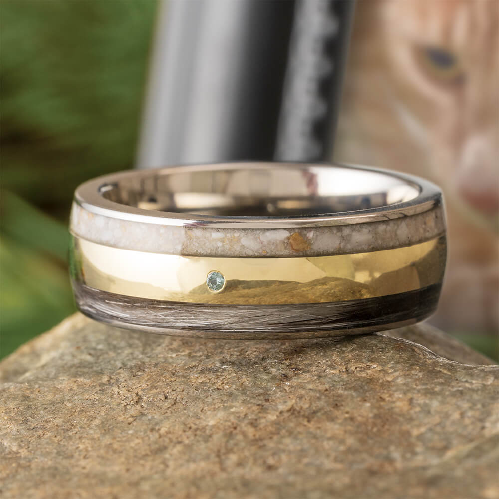 Two-toned ring with gold and silver bands on a stone surface