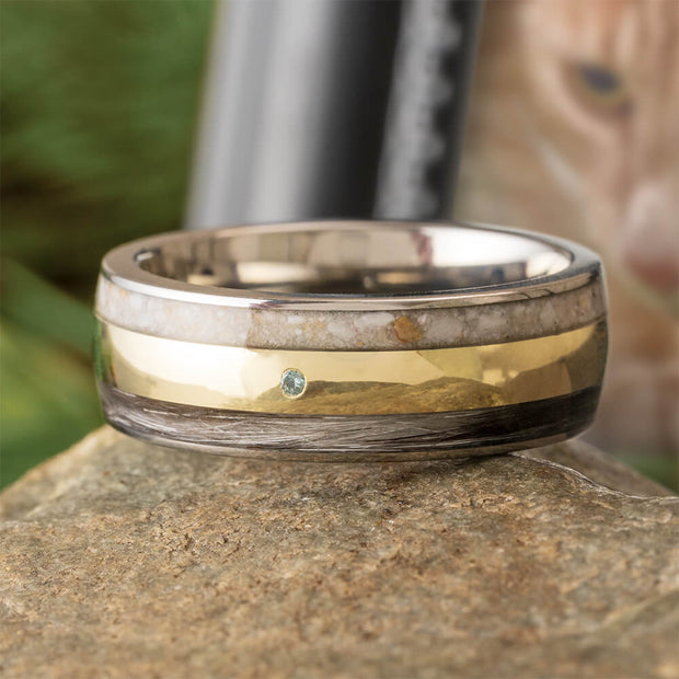 Two-toned ring with gold and silver bands on a stone surface